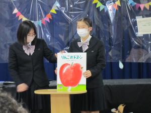 おおきなリンゴのおはなしの、おおがたえほんをよみきかせするこうこうせい